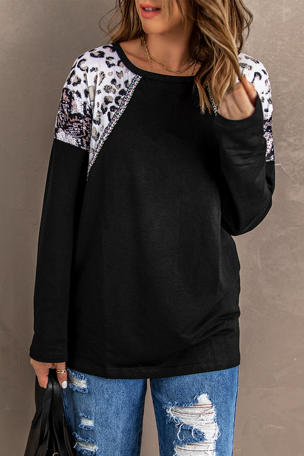 Black long sleeve top featuring a leopard snakeskin print, showcasing its stylish design and comfortable fabric.