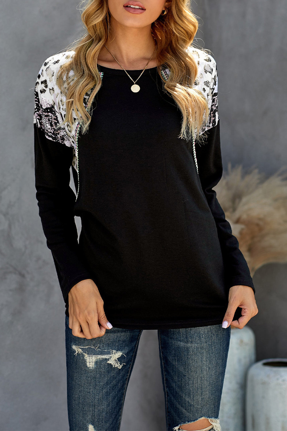 Black long sleeve top featuring a leopard snakeskin print, showcasing its stylish design and comfortable fabric.