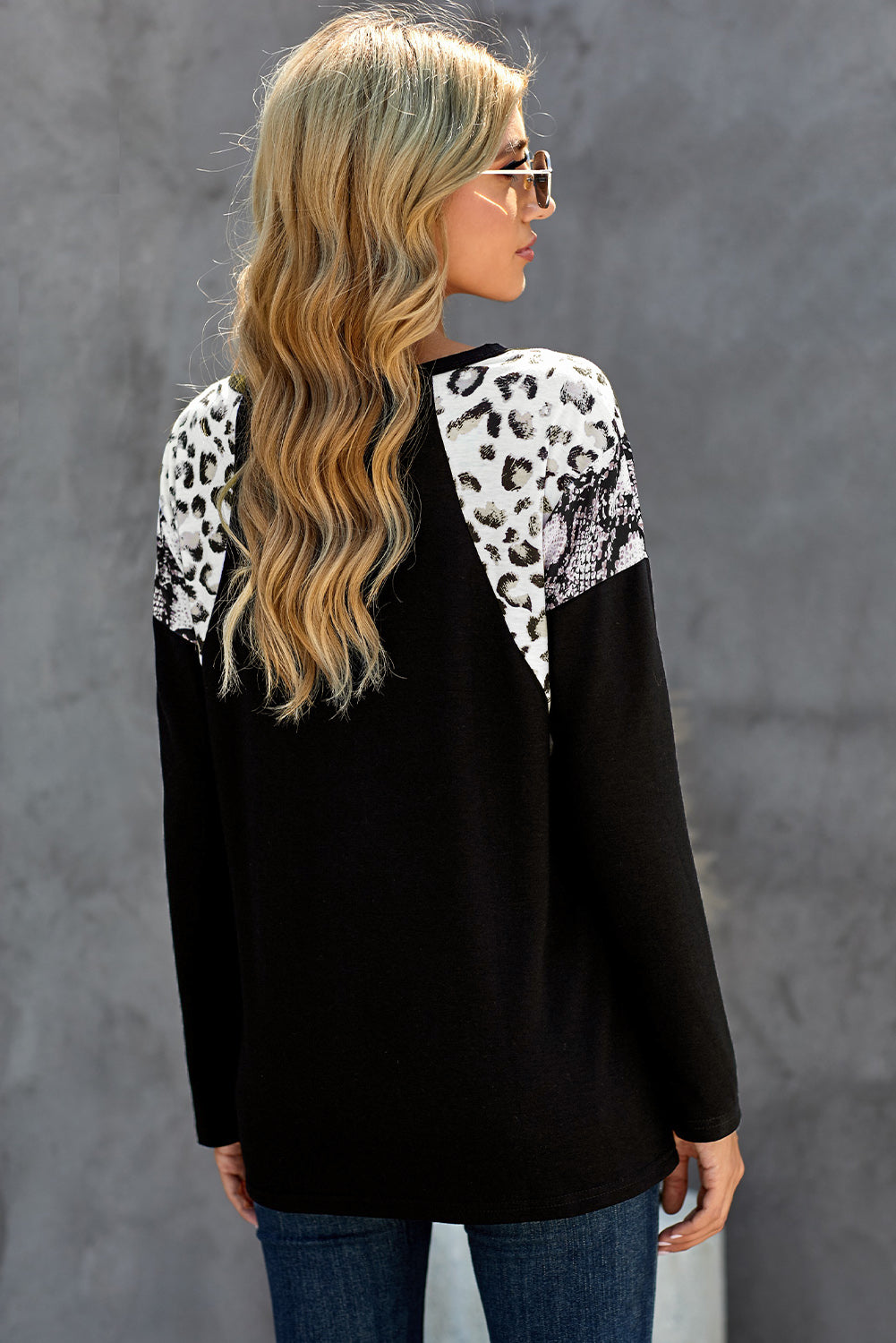 Black long sleeve top featuring a leopard snakeskin print, showcasing its stylish design and comfortable fabric.