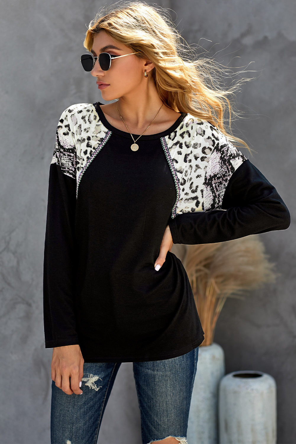 Black long sleeve top featuring a leopard snakeskin print, showcasing its stylish design and comfortable fabric.