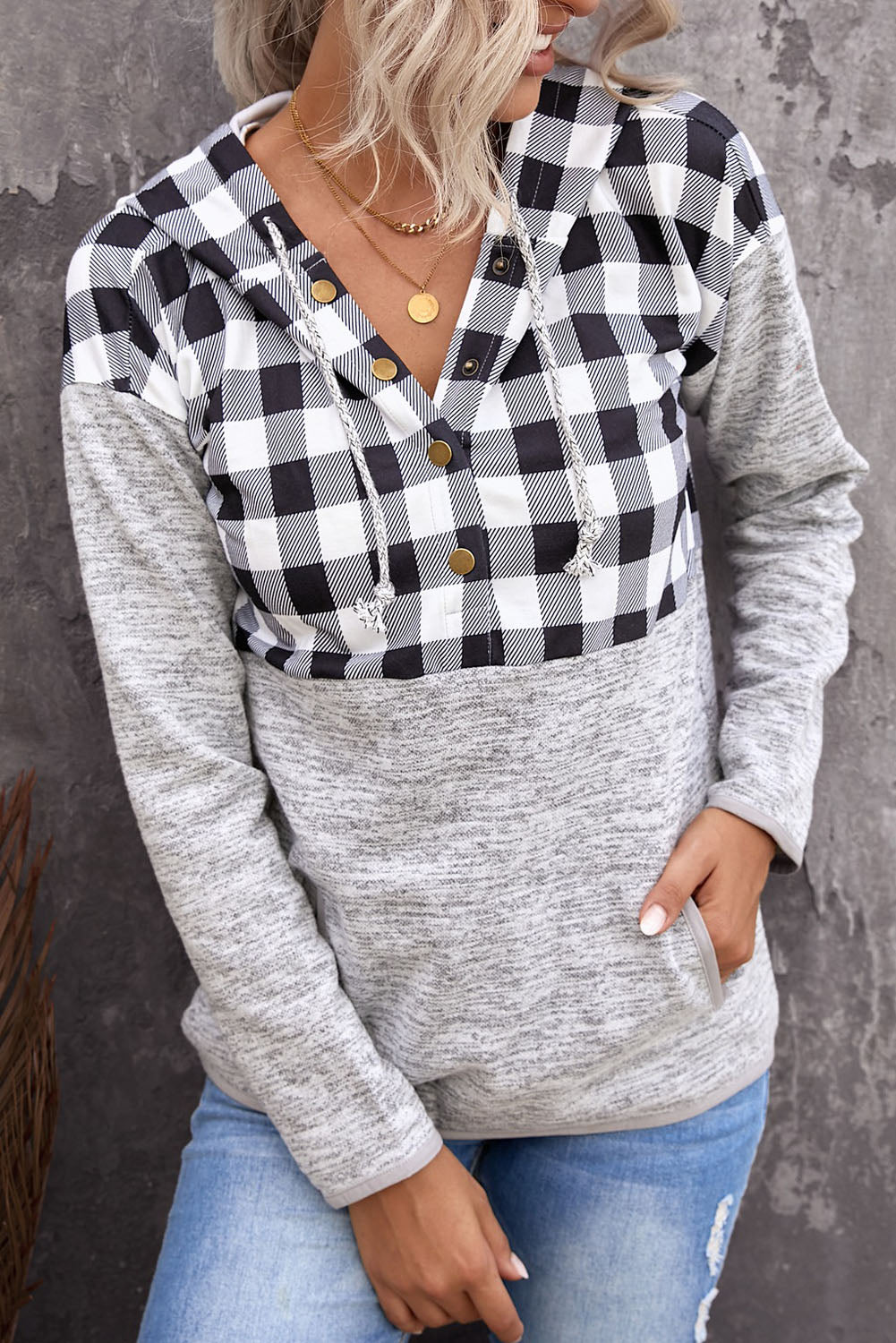 Black plaid splicing pocketed hoodie featuring a loose design and buttoned neckline, perfect for autumn wear.