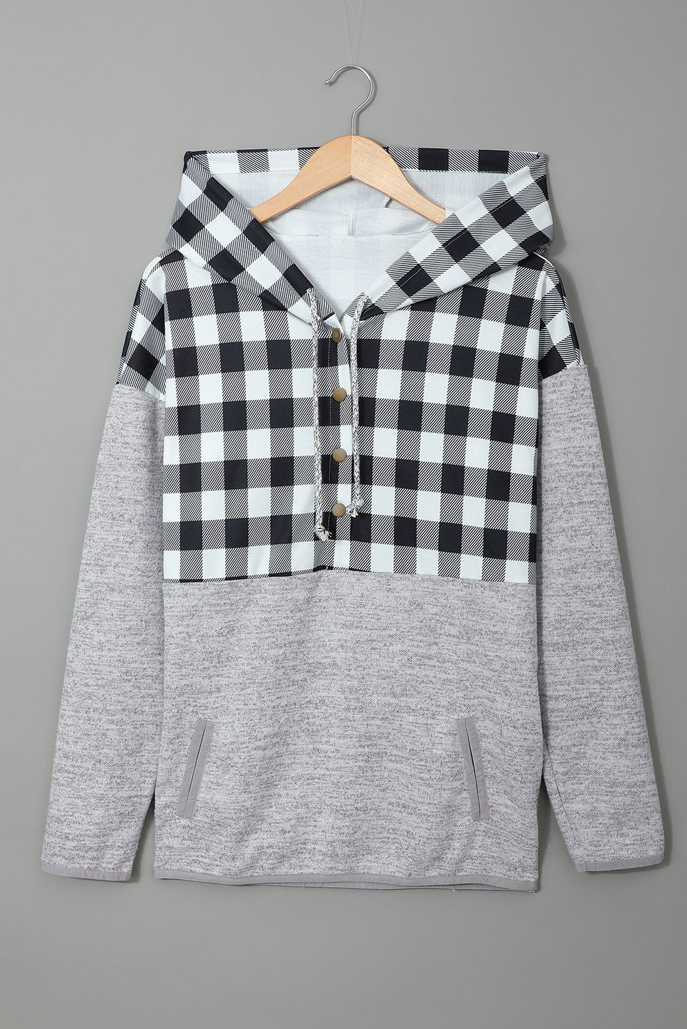 Black plaid splicing pocketed hoodie featuring a loose design and buttoned neckline, perfect for autumn wear.