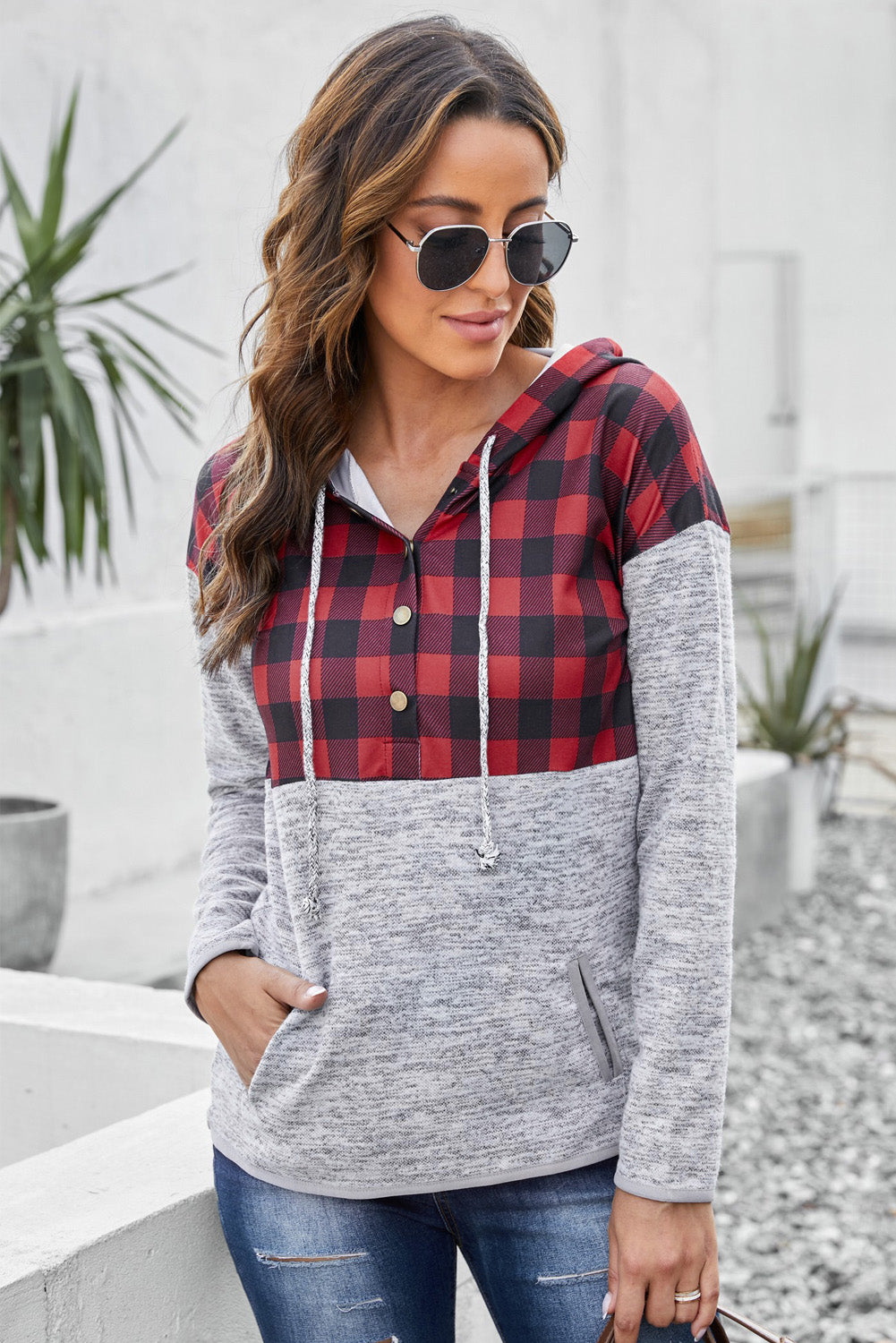 Black plaid splicing pocketed hoodie featuring a loose design and buttoned neckline, perfect for autumn wear.