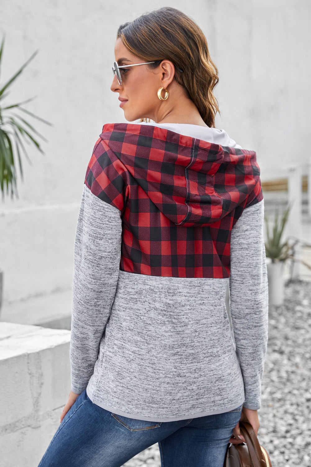 Black plaid splicing pocketed hoodie featuring a loose design and buttoned neckline, perfect for autumn wear.