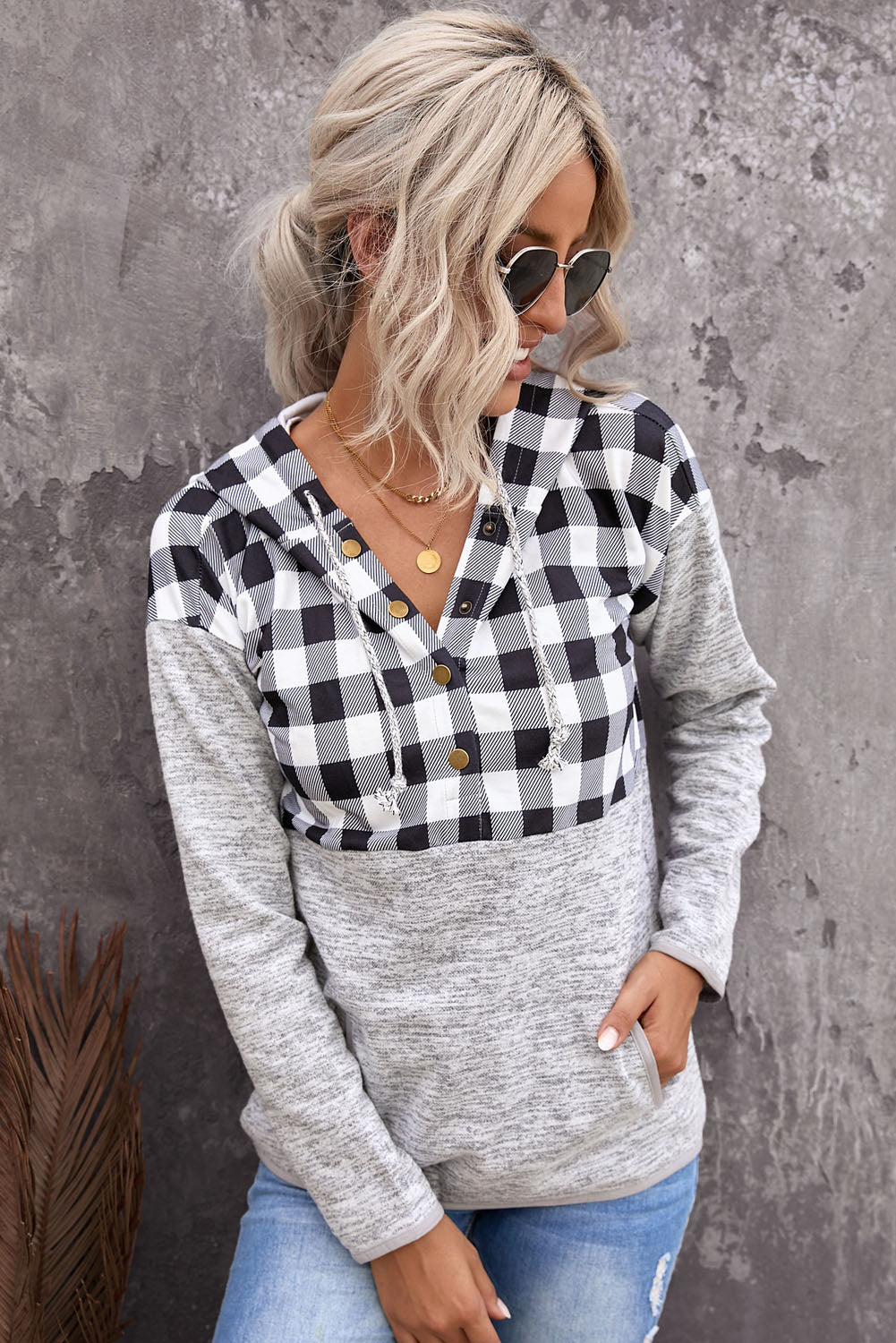 Black plaid splicing pocketed hoodie featuring a loose design and buttoned neckline, perfect for autumn wear.