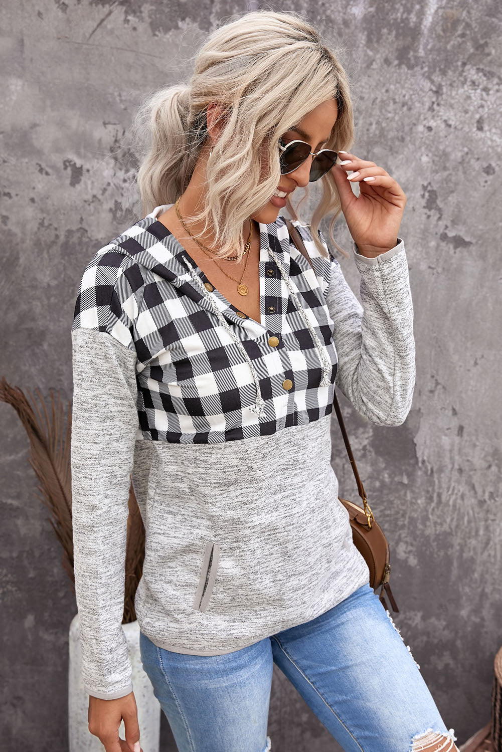 Black plaid splicing pocketed hoodie featuring a loose design and buttoned neckline, perfect for autumn wear.