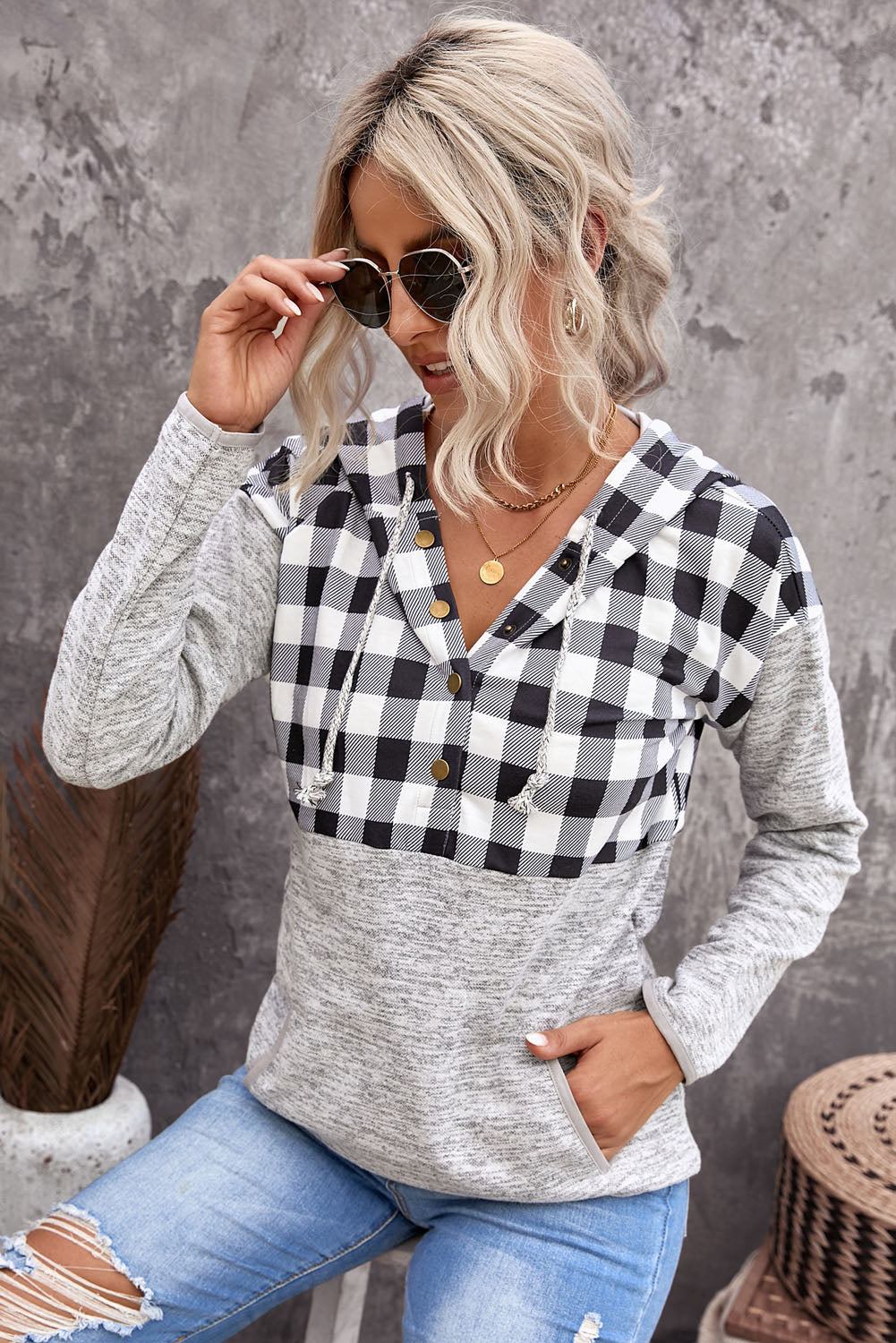 Black plaid splicing pocketed hoodie featuring a loose design and buttoned neckline, perfect for autumn wear.