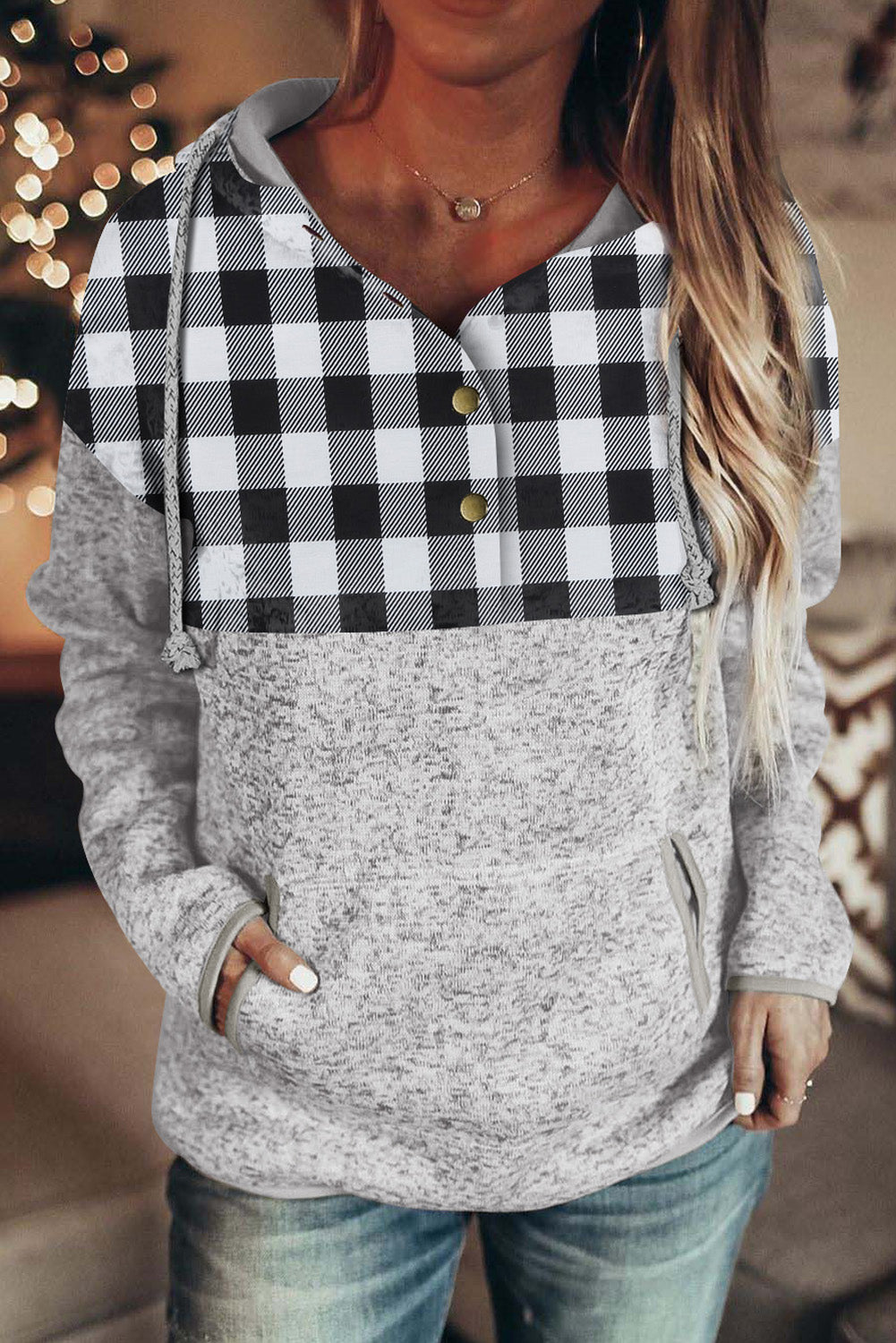 Black plaid splicing pocketed hoodie featuring a loose design and buttoned neckline, perfect for autumn wear.