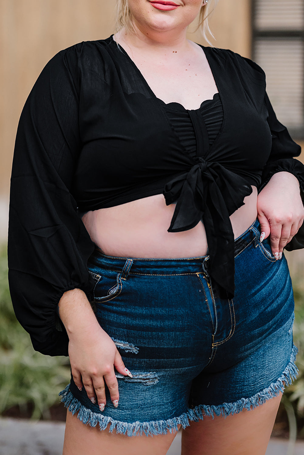 Black Plus Size Balloon Sleeve Wrap Top featuring a v-neck and tie front design, elegantly styled with balloon sleeves.