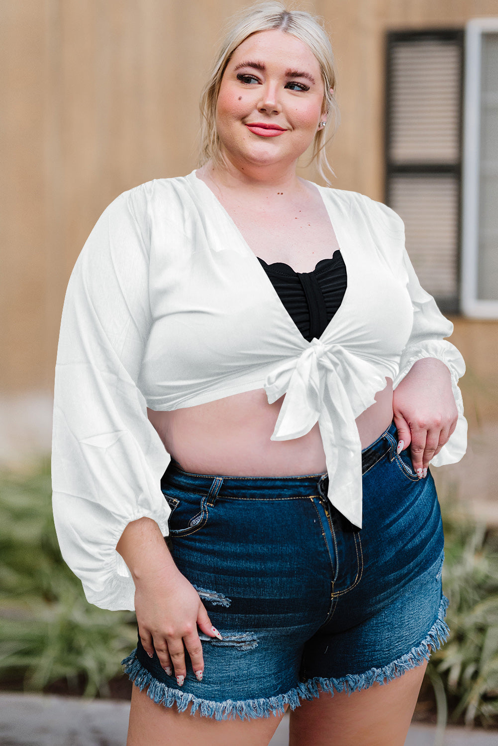 Black Plus Size Balloon Sleeve Wrap Top featuring a v-neck and tie front design, elegantly styled with balloon sleeves.