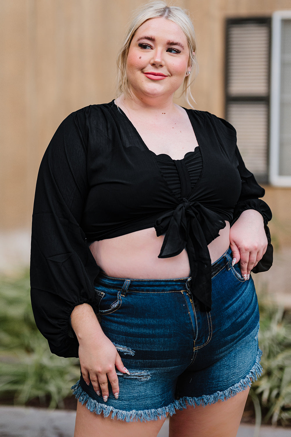 Black Plus Size Balloon Sleeve Wrap Top featuring a v-neck and tie front design, elegantly styled with balloon sleeves.