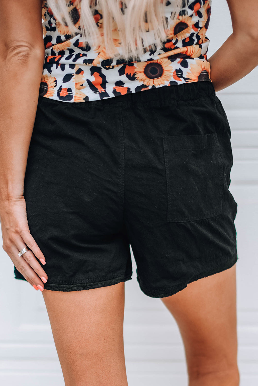 Black casual shorts with raw hem and pockets, featuring a drawstring waist for adjustable fit.