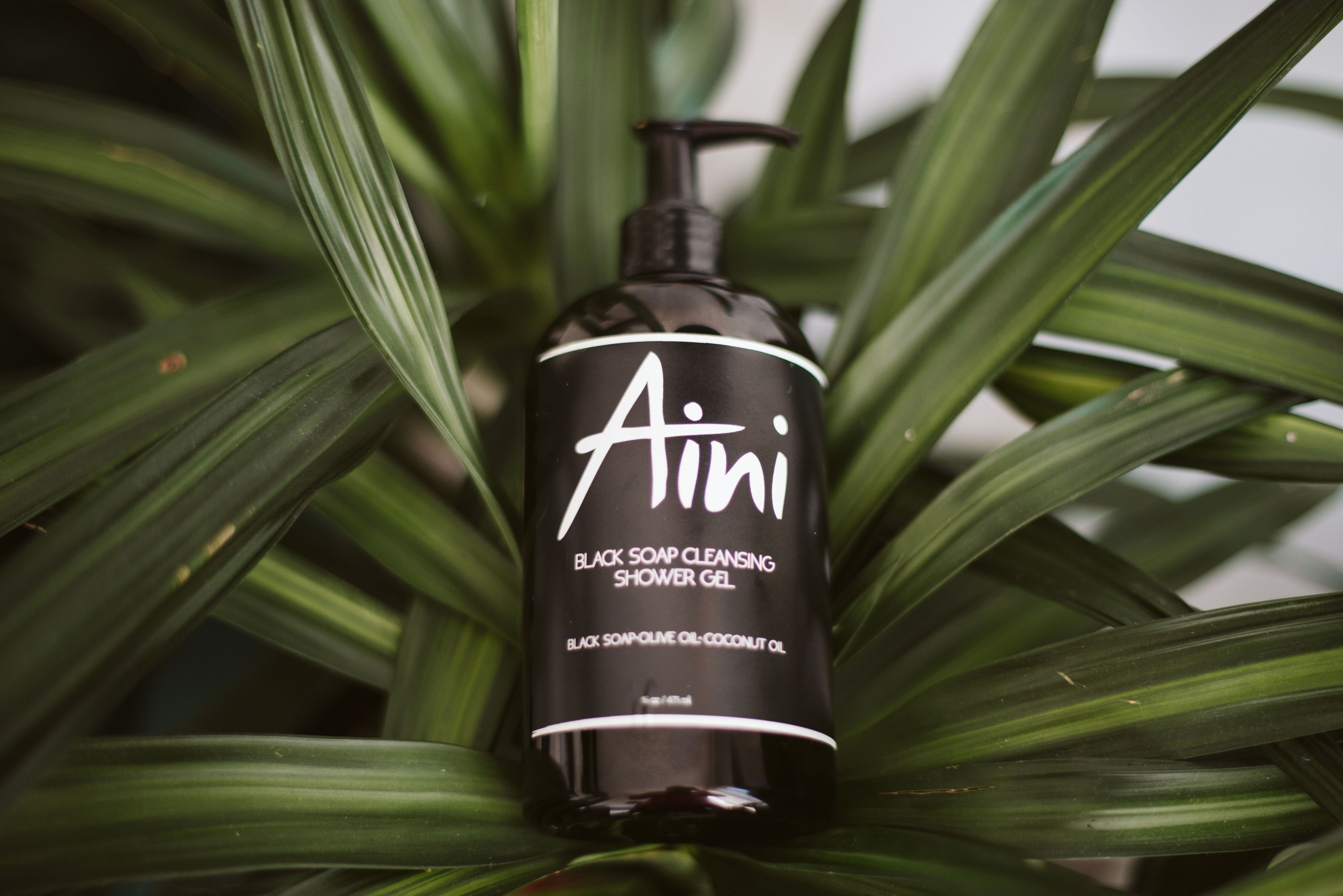 A bottle of Black Soap Cleansing Shower Gel with a rich lather, showcasing its luxurious texture and natural ingredients.