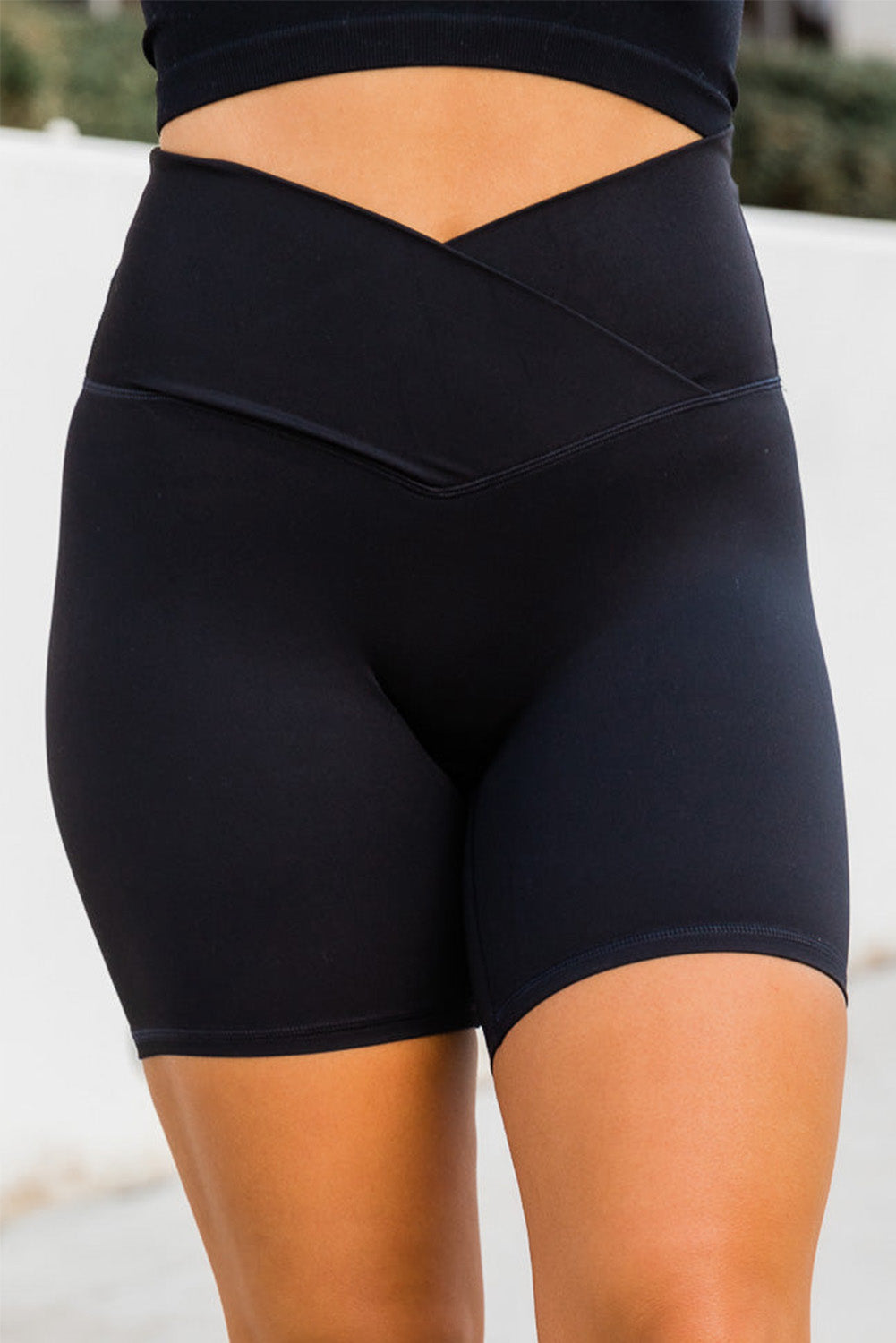 Black solid color yoga shorts with a V-shaped waistband, designed for comfort and style during workouts.