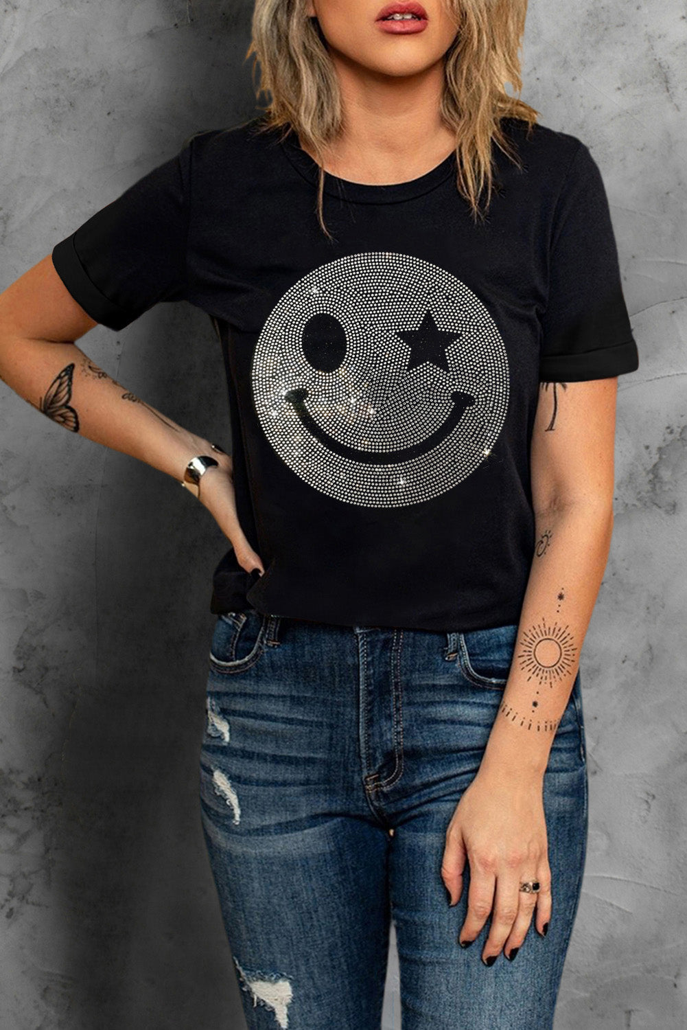 Black t-shirt featuring a sparkling rhinestone smile face graphic, perfect for casual wear.