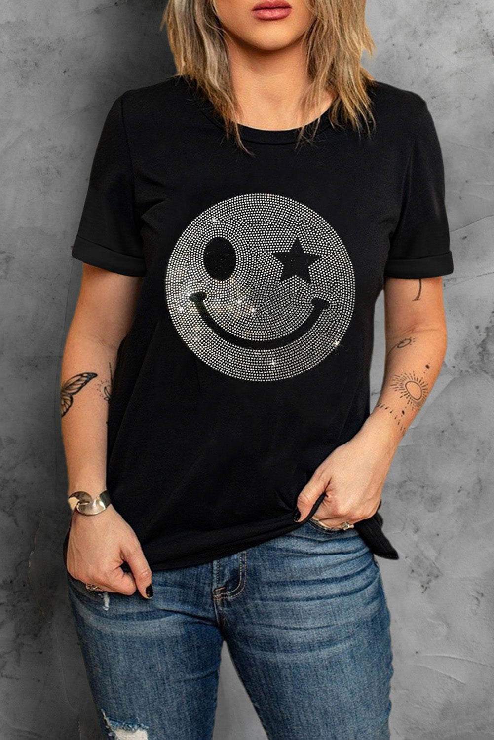 Black t-shirt featuring a sparkling rhinestone smile face graphic, perfect for casual wear.