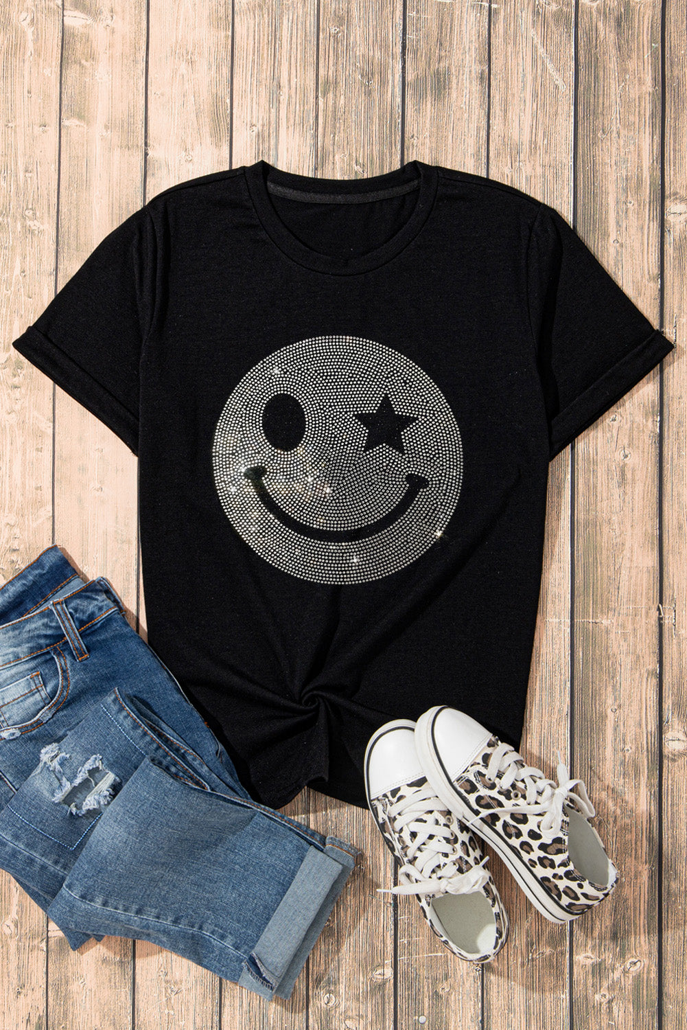 Black t-shirt featuring a sparkling rhinestone smile face graphic, perfect for casual wear.