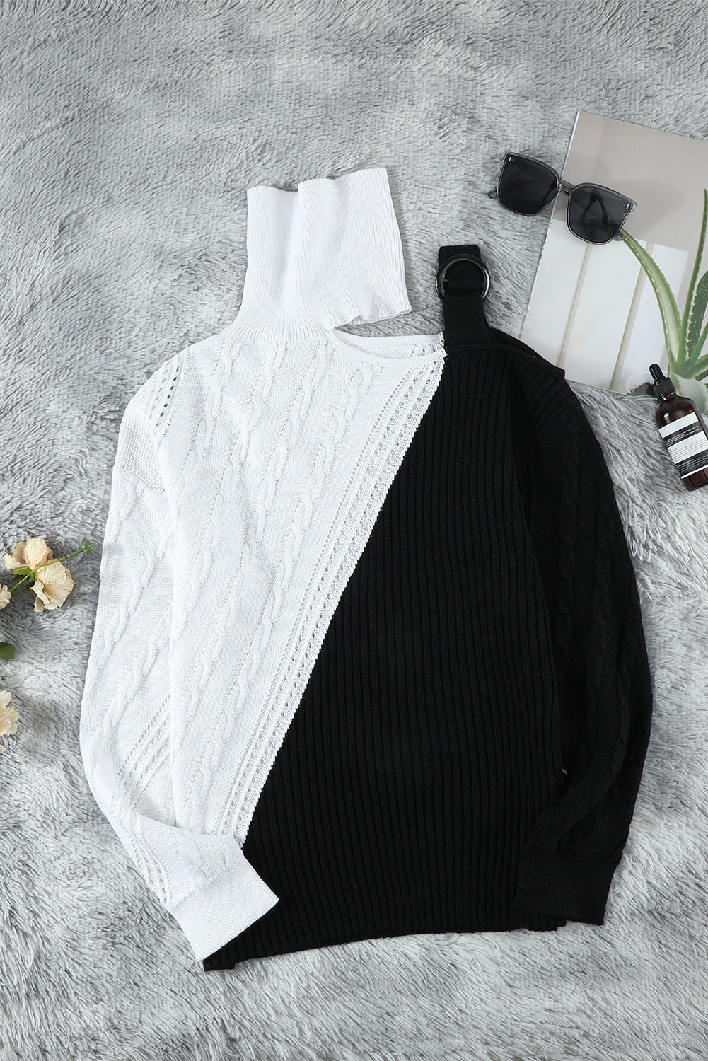 A stylish black turtleneck sweater featuring cold shoulder design and buckled decor, perfect for chic winter outfits.