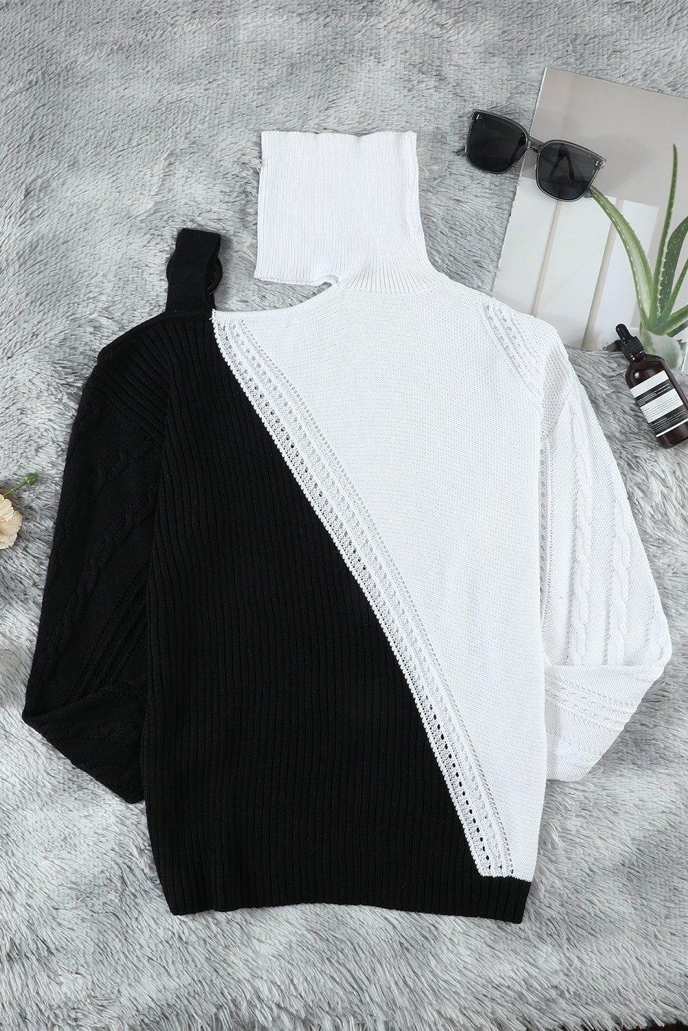 A stylish black turtleneck sweater featuring cold shoulder design and buckled decor, perfect for chic winter outfits.