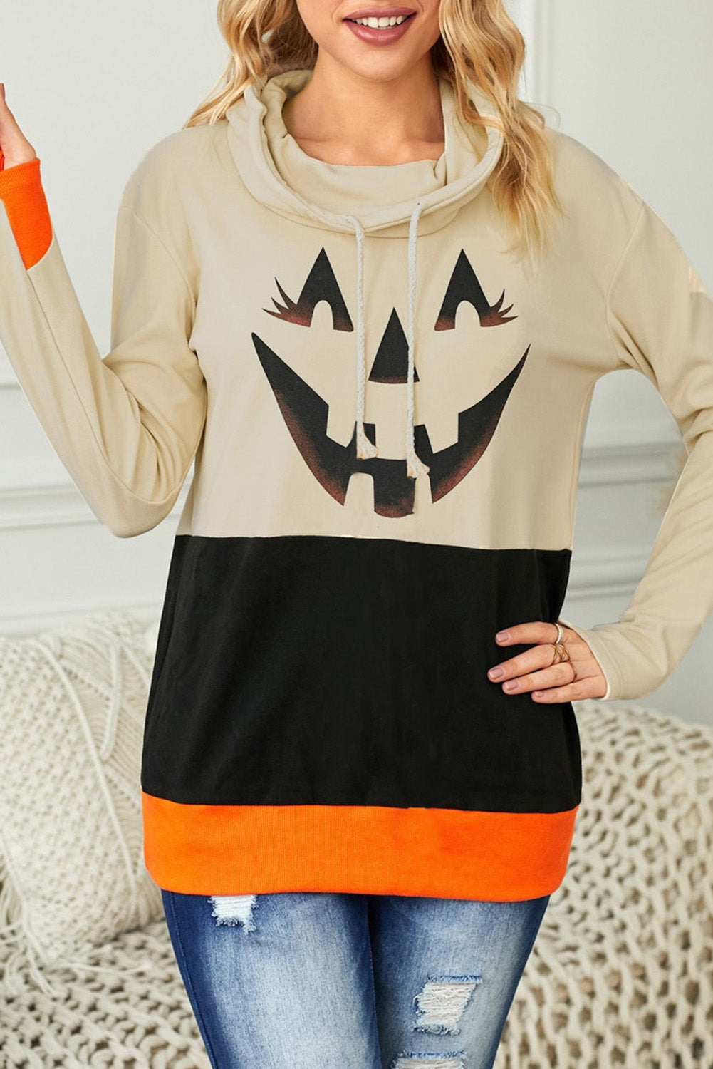 Black turtleneck top with pumpkin print, perfect for Halloween festivities, featuring long sleeves and a trendy color block design.