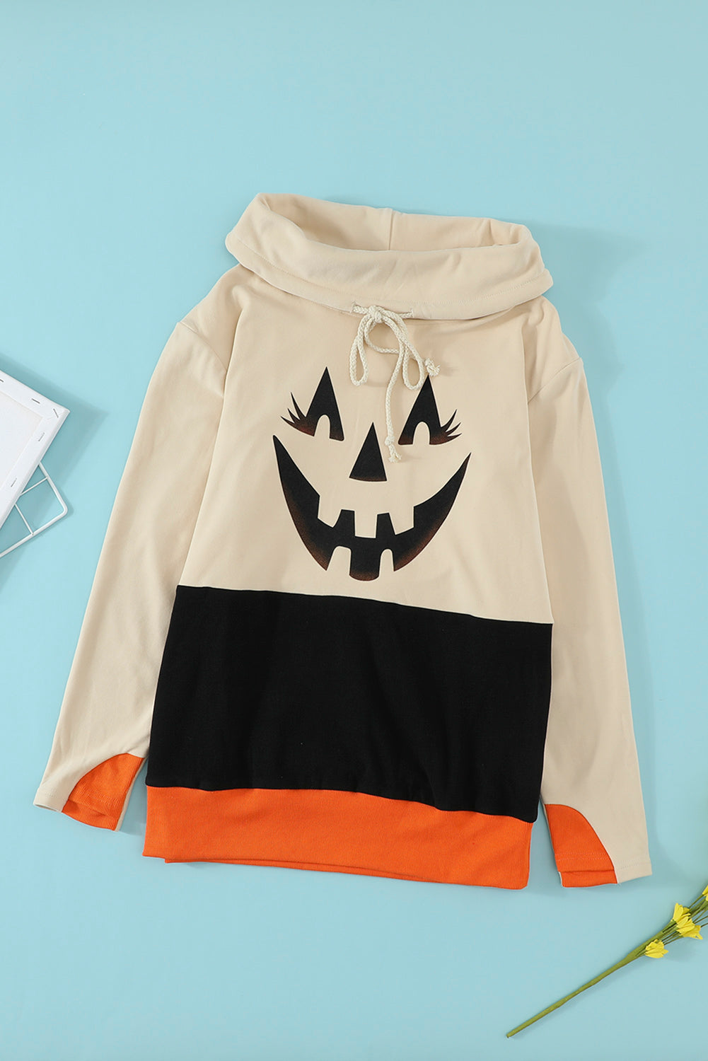 Black turtleneck top with pumpkin print, perfect for Halloween festivities, featuring long sleeves and a trendy color block design.