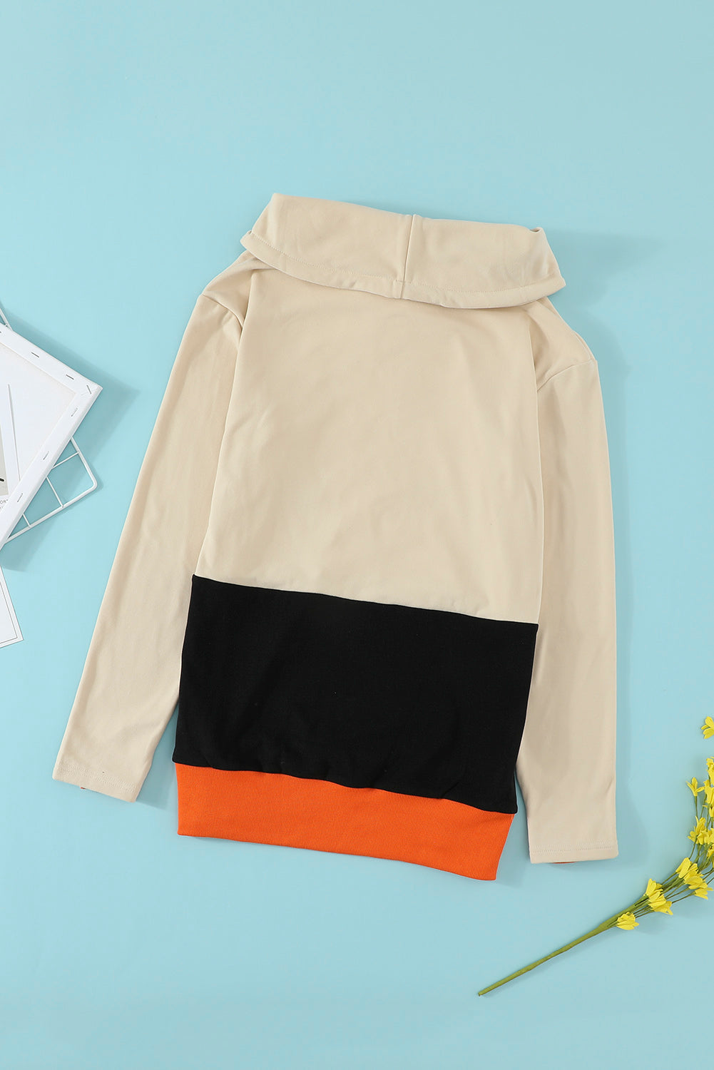 Black turtleneck top with pumpkin print, perfect for Halloween festivities, featuring long sleeves and a trendy color block design.