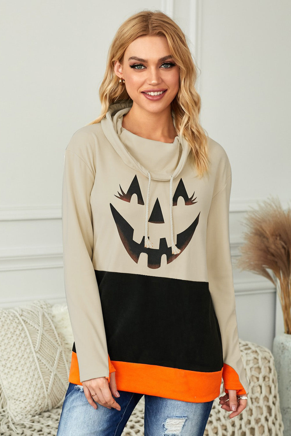 Black turtleneck top with pumpkin print, perfect for Halloween festivities, featuring long sleeves and a trendy color block design.