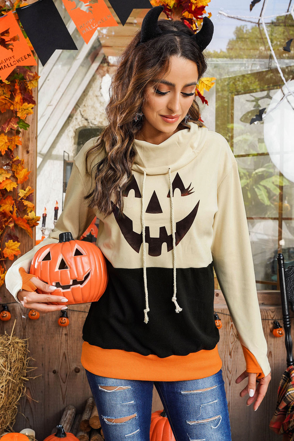 Black turtleneck top with pumpkin print, perfect for Halloween festivities, featuring long sleeves and a trendy color block design.