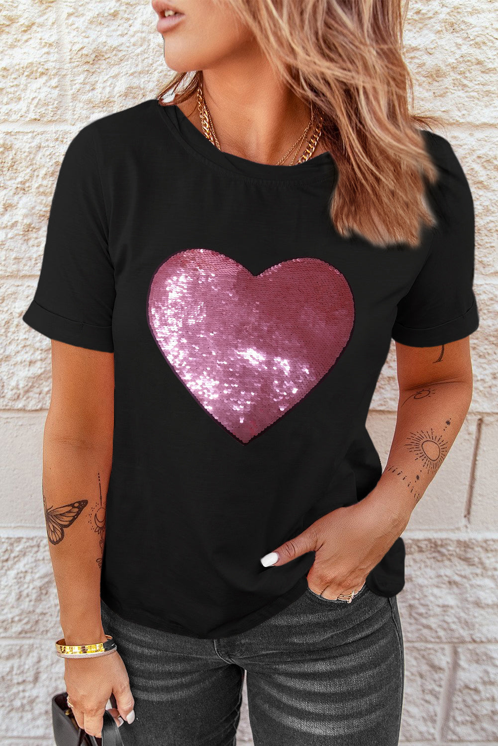 Black crew neck t-shirt featuring a sparkling heart-shaped sequin design, perfect for Valentine's Day celebrations.