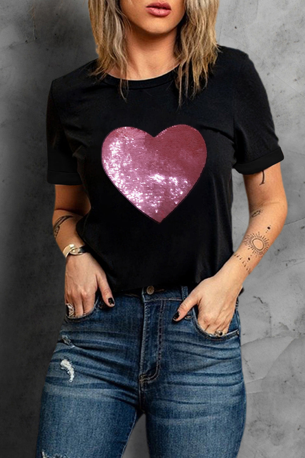 Black crew neck t-shirt featuring a sparkling heart-shaped sequin design, perfect for Valentine's Day celebrations.