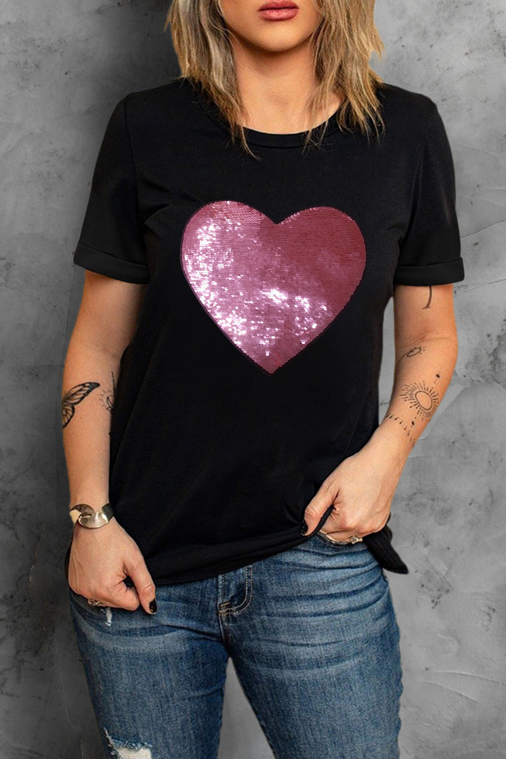 Black crew neck t-shirt featuring a sparkling heart-shaped sequin design, perfect for Valentine's Day celebrations.