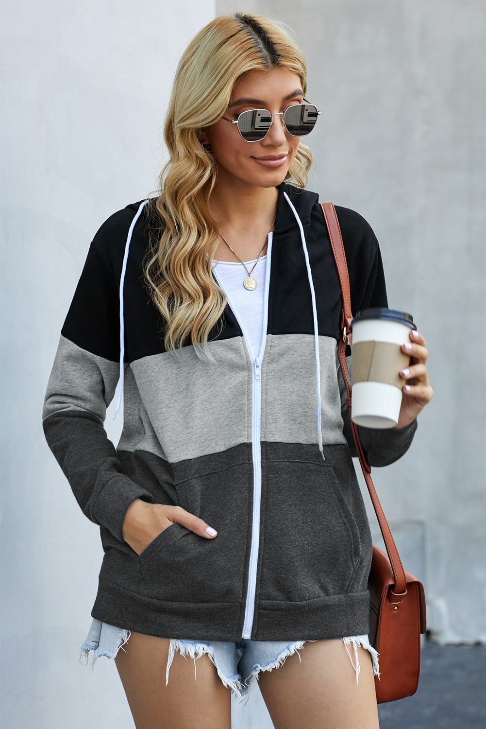 Black zip front hoodie featuring color block splicing and drawstring hood, perfect for casual wear.