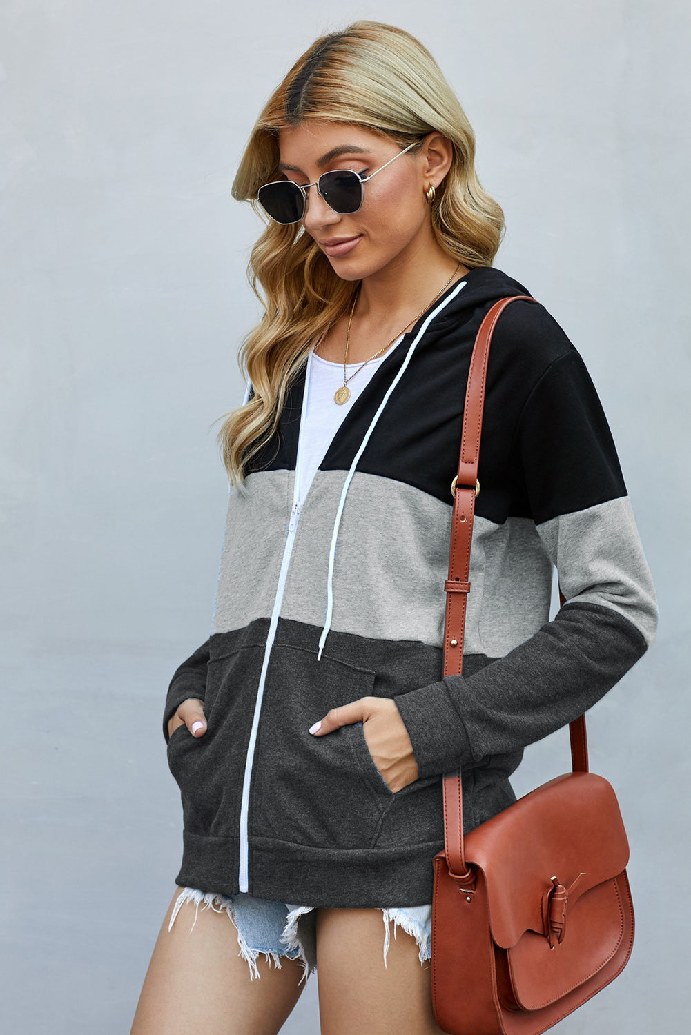 Black zip front hoodie featuring color block splicing and drawstring hood, perfect for casual wear.