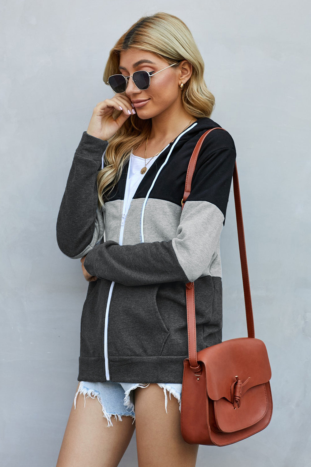 Black zip front hoodie featuring color block splicing and drawstring hood, perfect for casual wear.