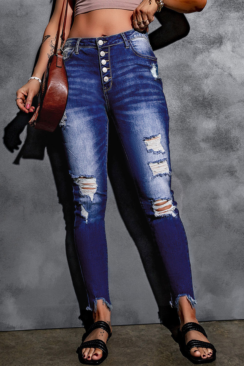 Blue high rise skinny jeans with button front and frayed ankle hem, showcasing a medium wash and distressed details.