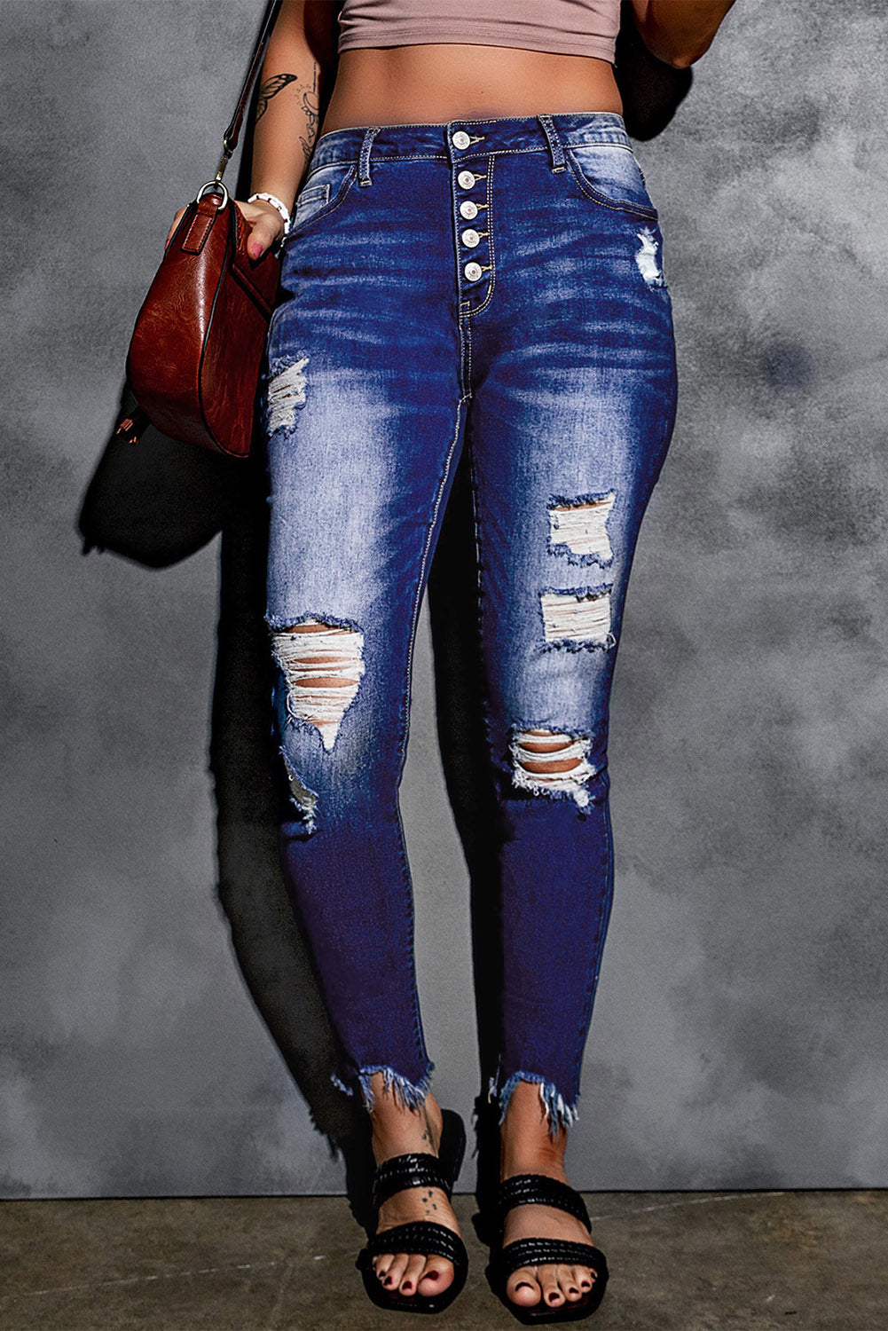 Blue high rise skinny jeans with button front and frayed ankle hem, showcasing a medium wash and distressed details.