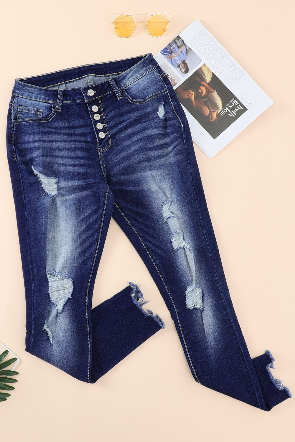 Blue high rise skinny jeans with button front and frayed ankle hem, showcasing a medium wash and distressed details.