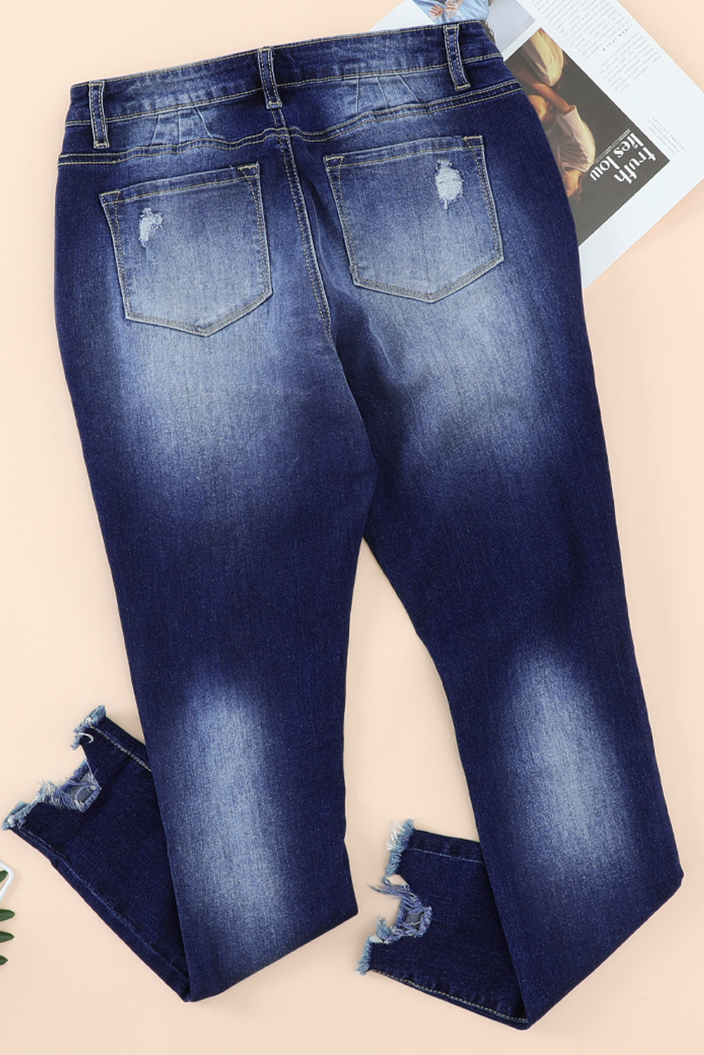 Blue high rise skinny jeans with button front and frayed ankle hem, showcasing a medium wash and distressed details.