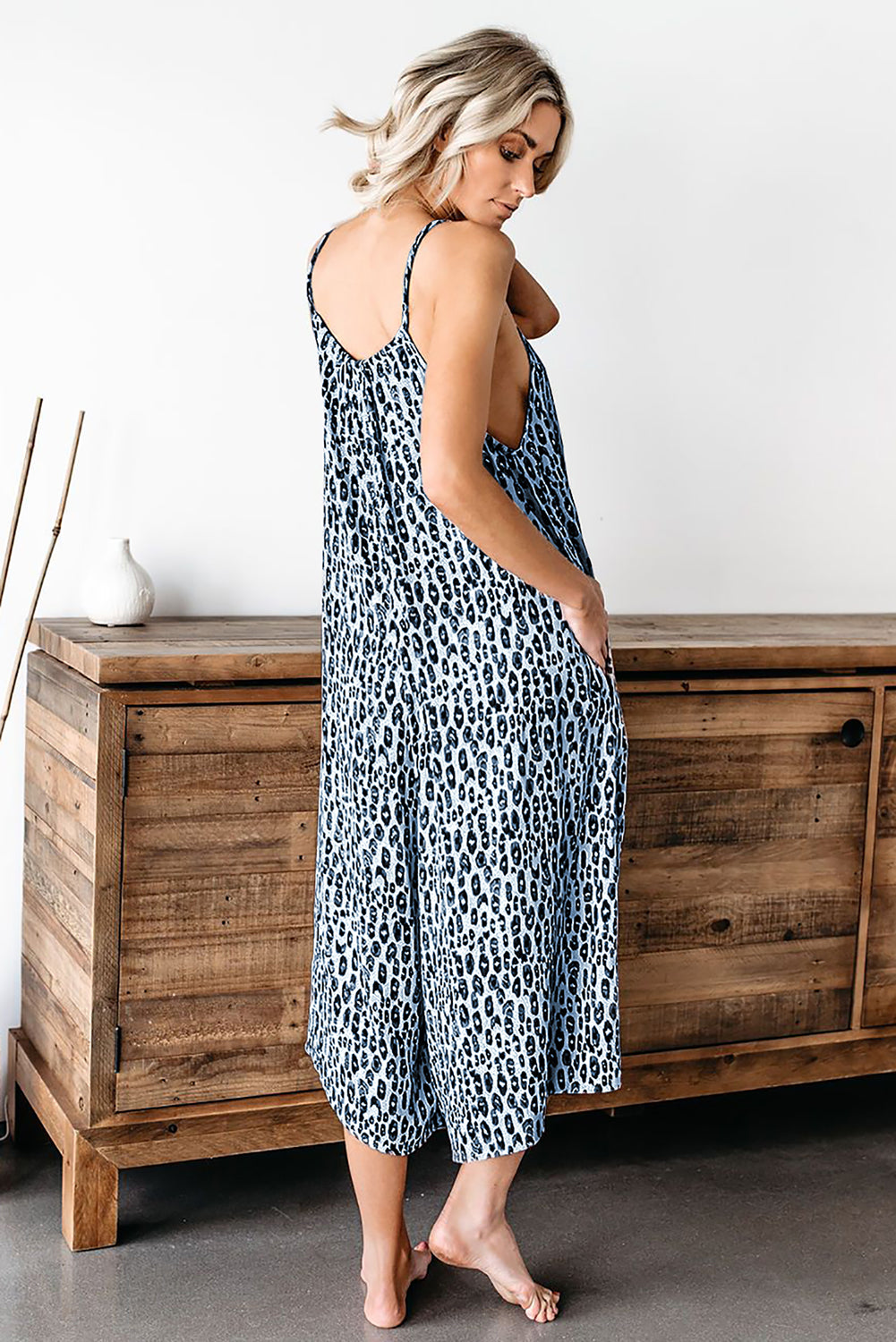 A stylish blue leopard print adjustable jumpsuit with thin straps and wide-leg trousers, perfect for summer wear.