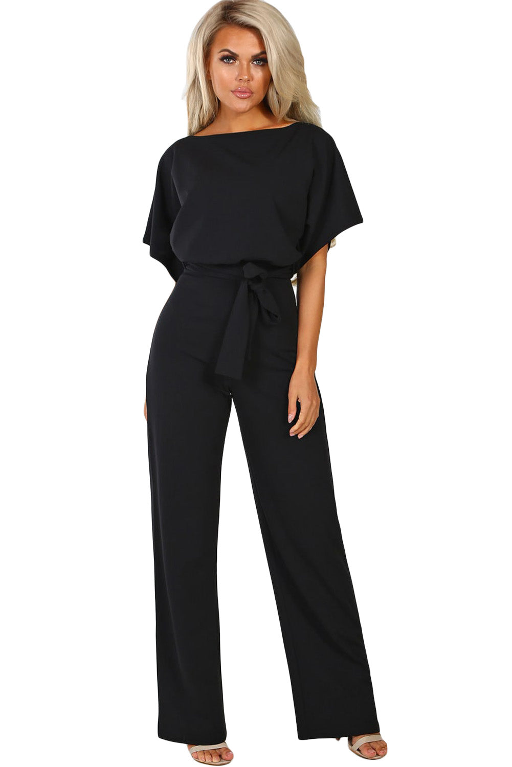 A stylish woman wearing a blue belted wide leg jumpsuit with batwing sleeves, showcasing a chic and glamorous look.