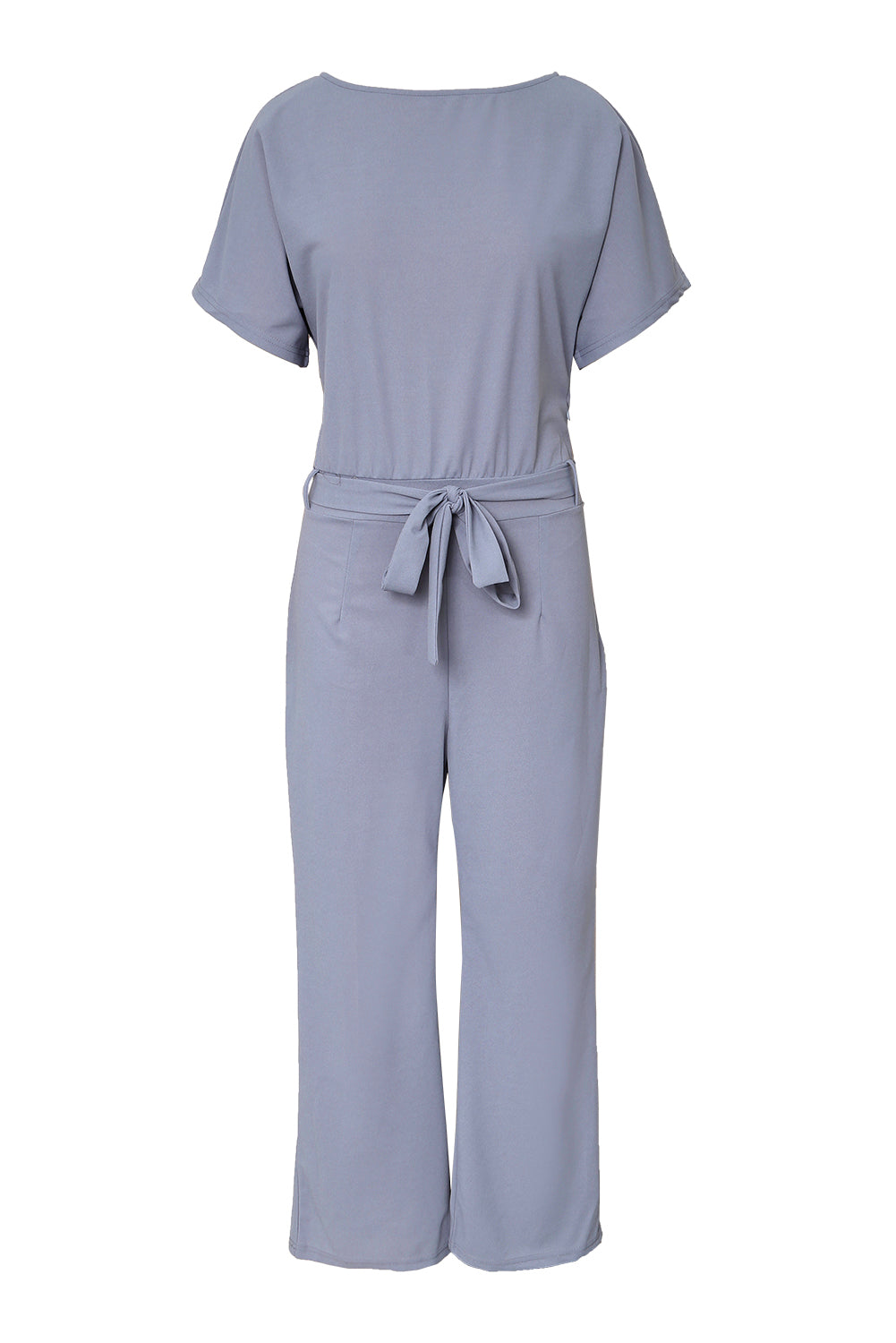 A stylish woman wearing a blue belted wide leg jumpsuit with batwing sleeves, showcasing a chic and glamorous look.