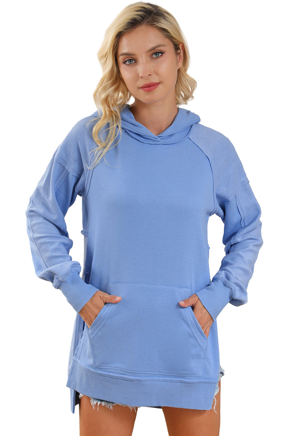 A stylish blue tunic hoodie featuring raw seams, patchwork design, and a kangaroo pocket, perfect for casual wear.