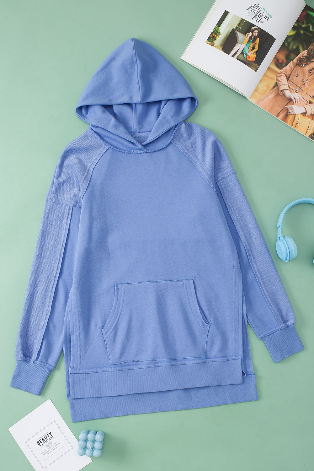 A stylish blue tunic hoodie featuring raw seams, patchwork design, and a kangaroo pocket, perfect for casual wear.