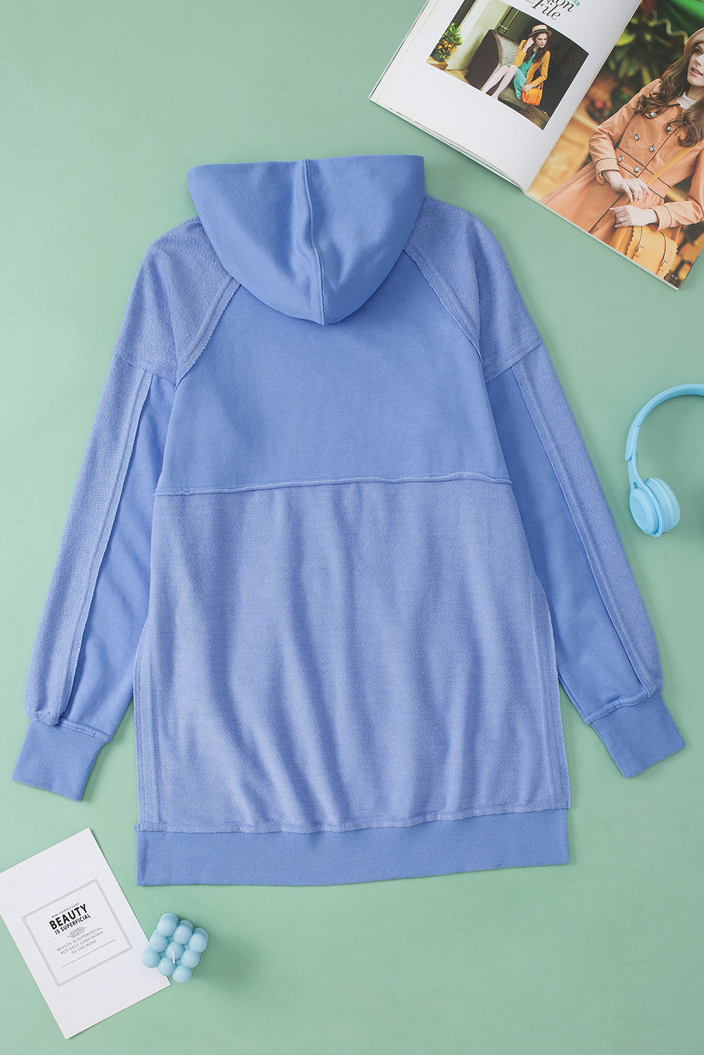 A stylish blue tunic hoodie featuring raw seams, patchwork design, and a kangaroo pocket, perfect for casual wear.