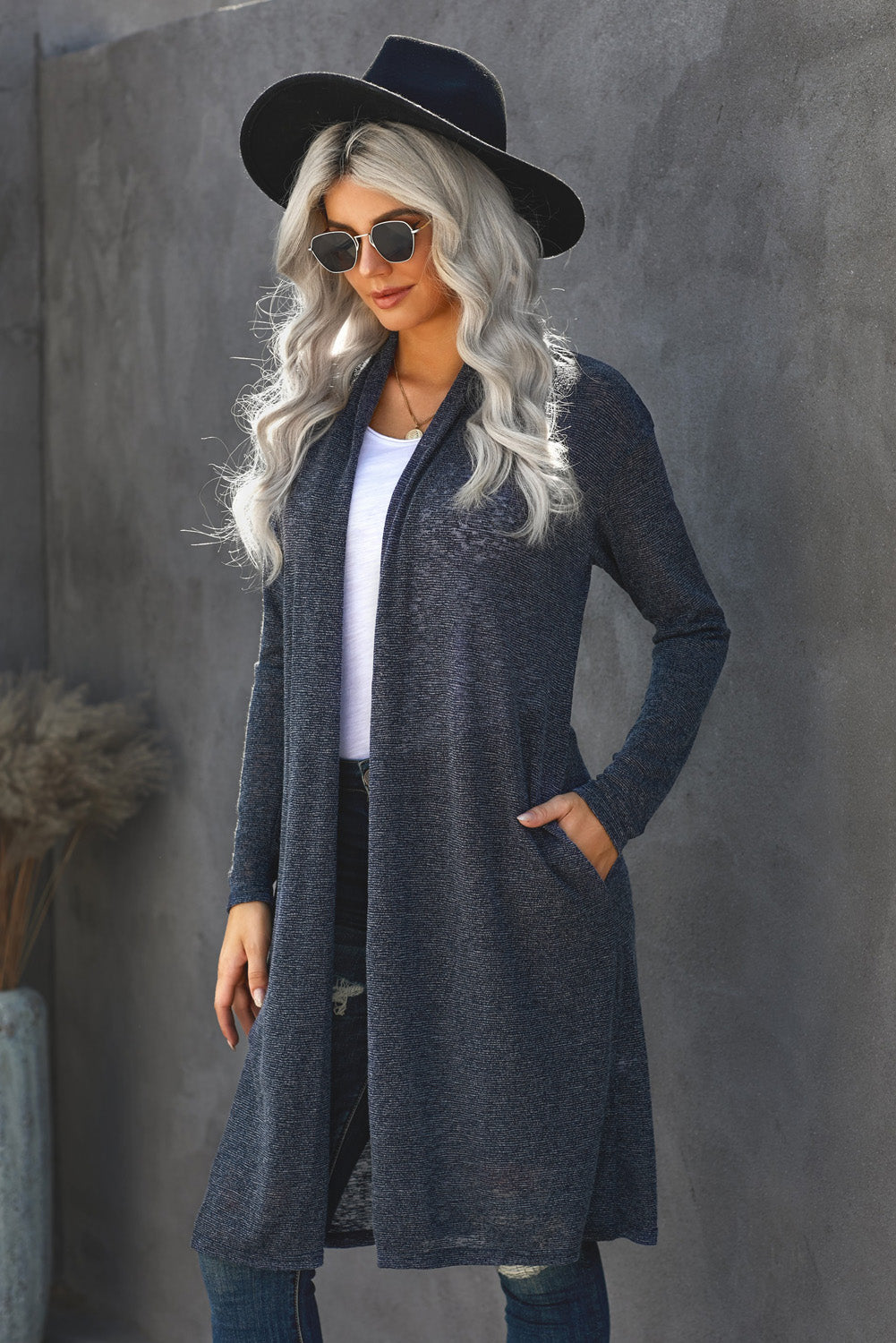 A stylish blue slouchy pocketed knit longline cardigan displayed on a mannequin, showcasing its relaxed fit and soft texture.