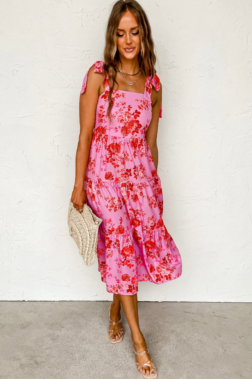 A beautiful blue tiered floral dress with tie shoulder straps, perfect for summer occasions.