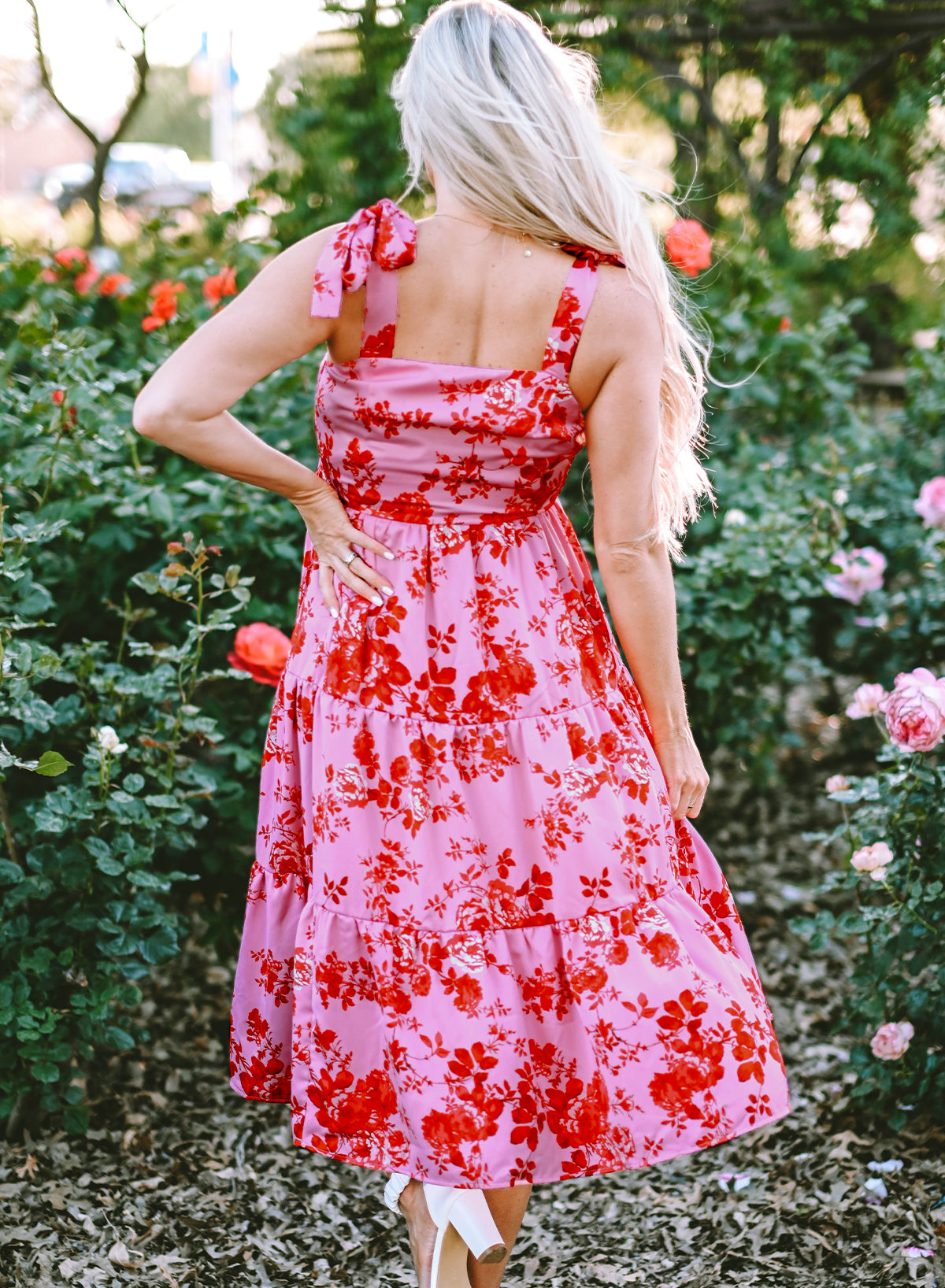 A beautiful blue tiered floral dress with tie shoulder straps, perfect for summer occasions.