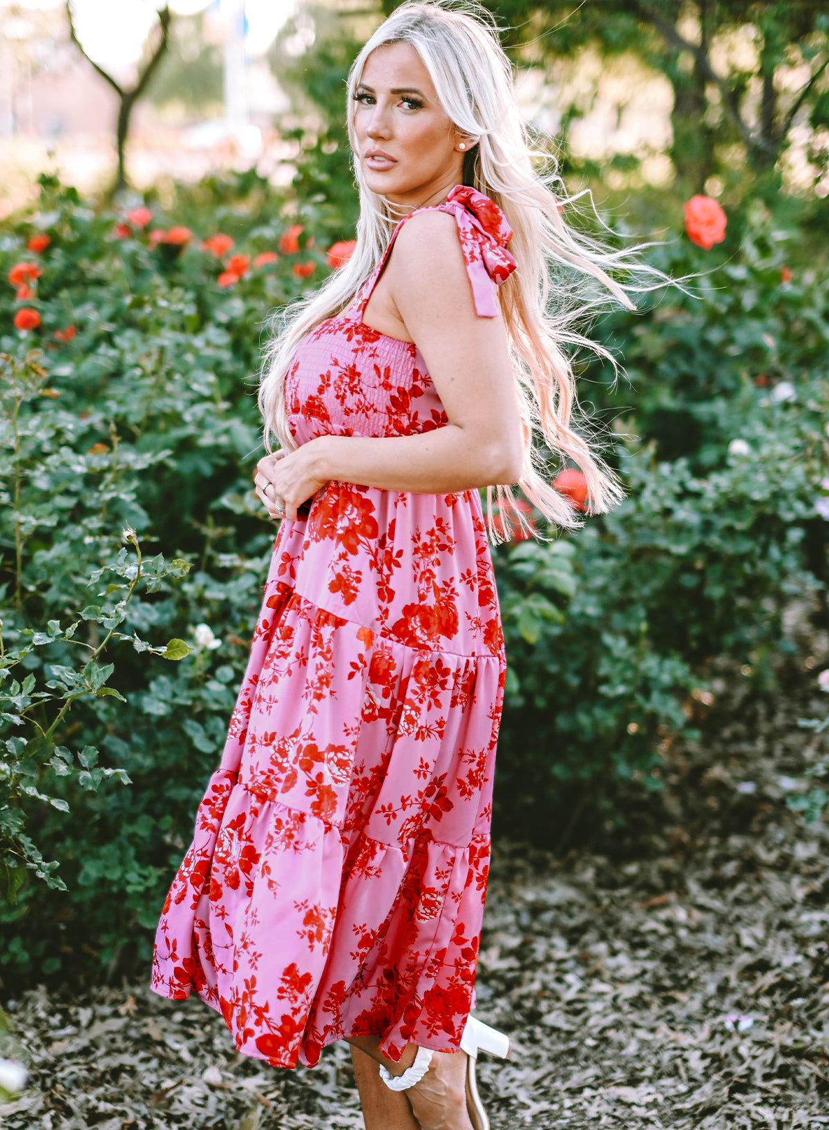 A beautiful blue tiered floral dress with tie shoulder straps, perfect for summer occasions.