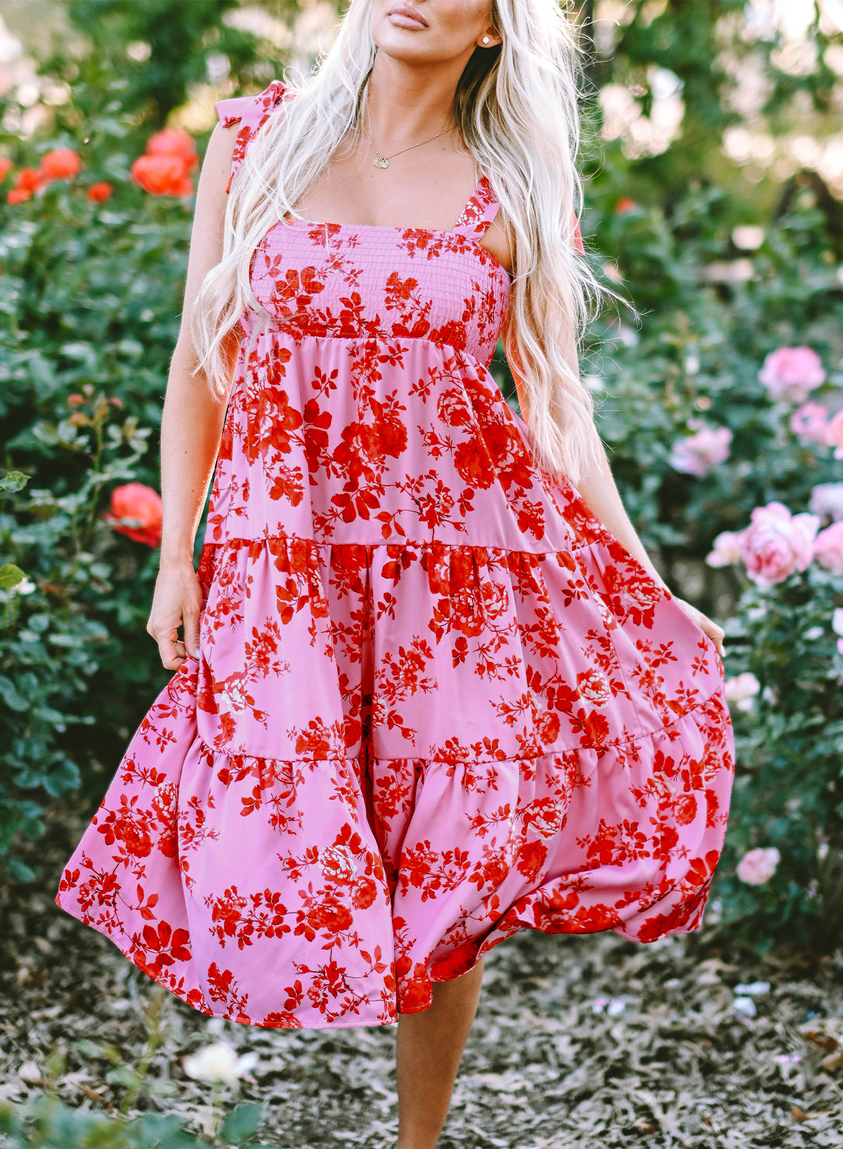 A beautiful blue tiered floral dress with tie shoulder straps, perfect for summer occasions.