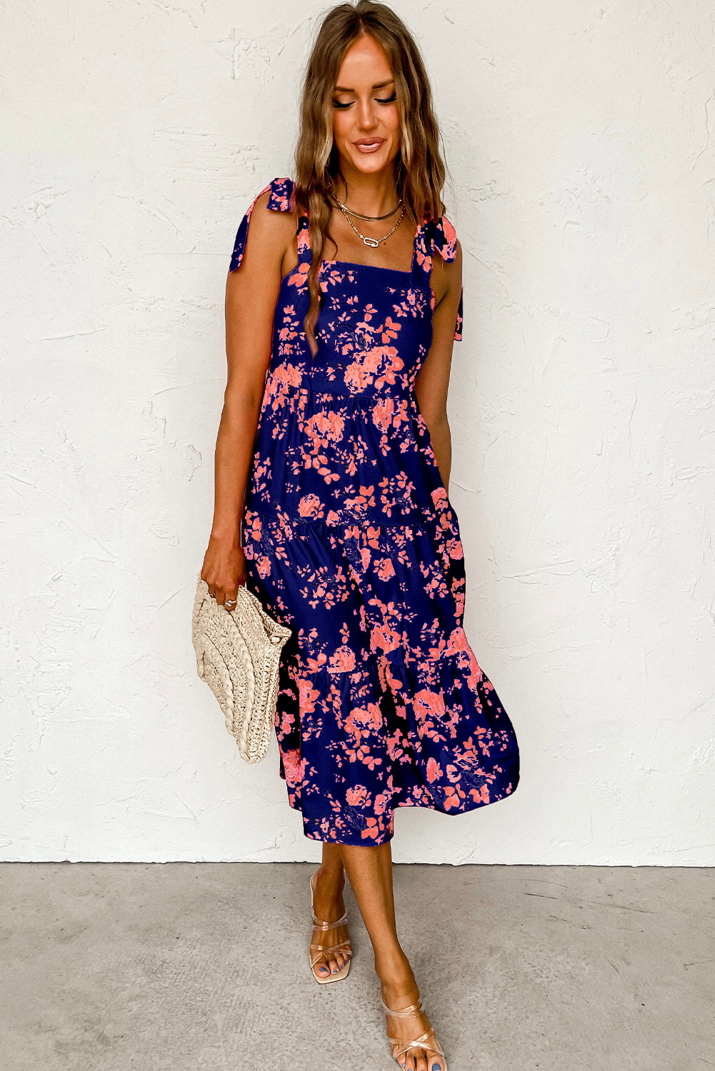 A beautiful blue tiered floral dress with tie shoulder straps, perfect for summer occasions.